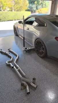 G82 M4 Competition in the garage with a new exhaust laid out